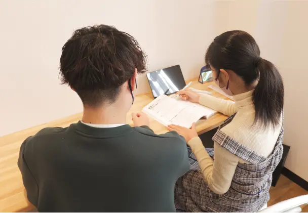 男性講師が女子生徒に個別で教えている様子